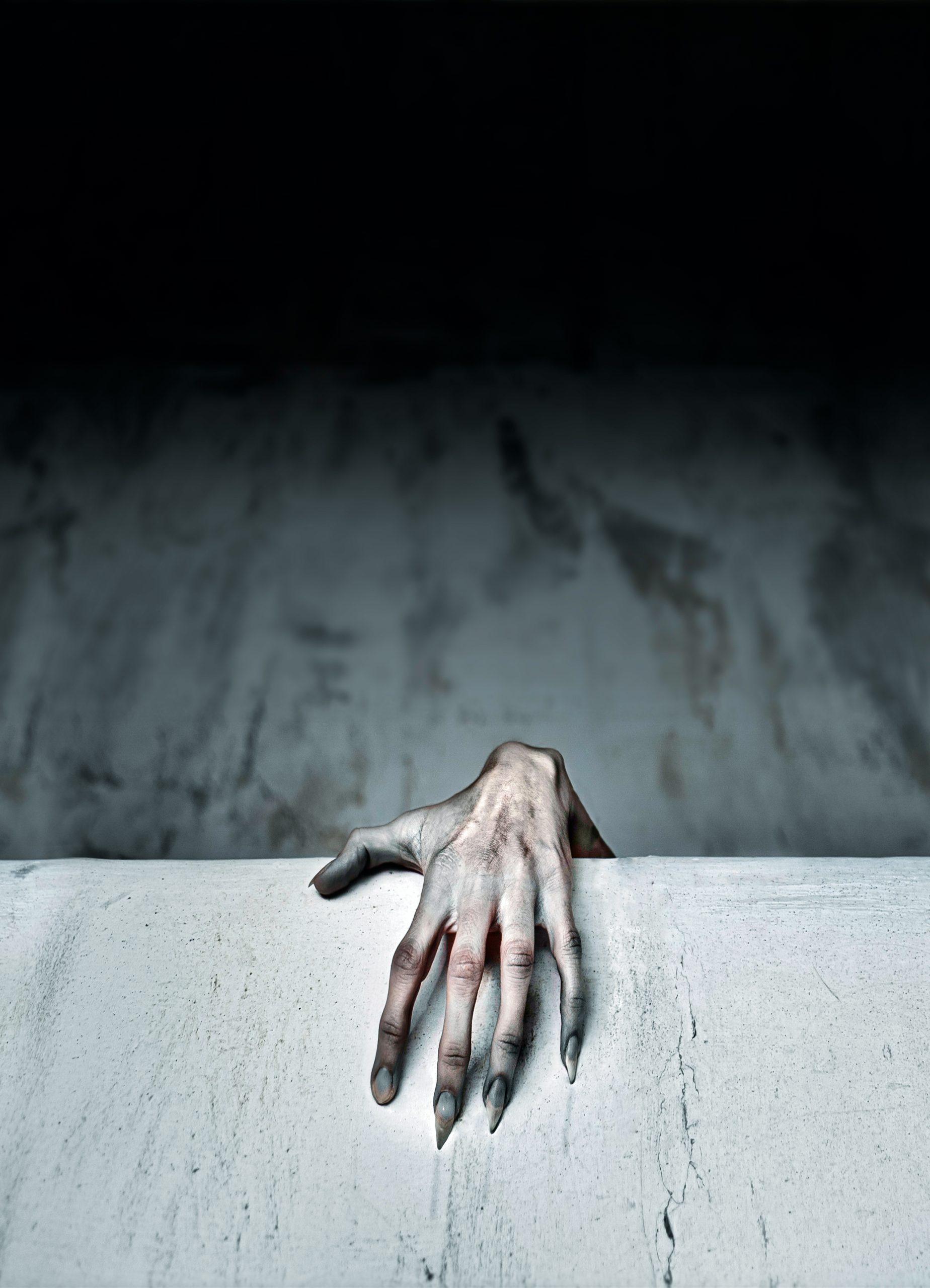 A spooky female hand protruding from behind a wall