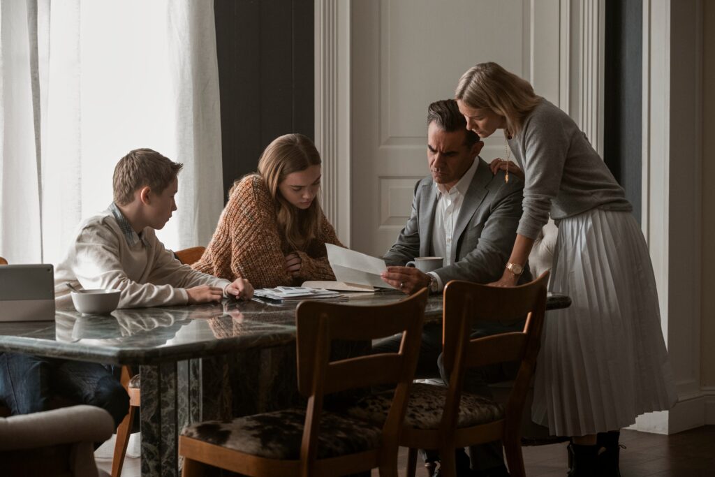 The Watcher. (L to R) Luke David Blumm as Carter Brannock, Isabel Marie Gravitt as Ellie Brannock, Bobby Cannavale as Dean Brannock, Naomi Watts as Nora Brannock in episode 101 of The Watcher.